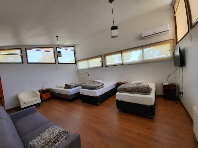 Unidad de tres camas del apart hotel en Pucón, con sofá y televisor