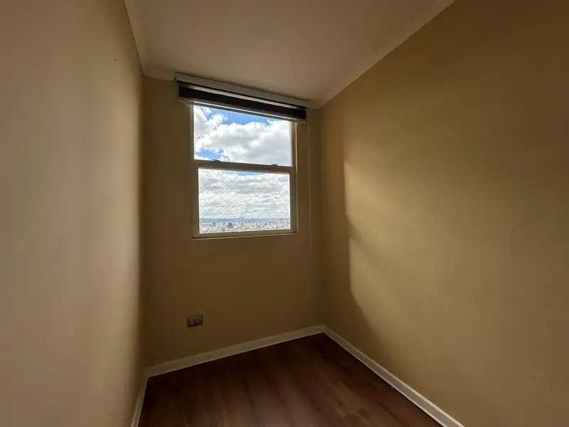 Dormitorio con vista a la ciudad del departamento en Condominio Plaza Club, Temuco