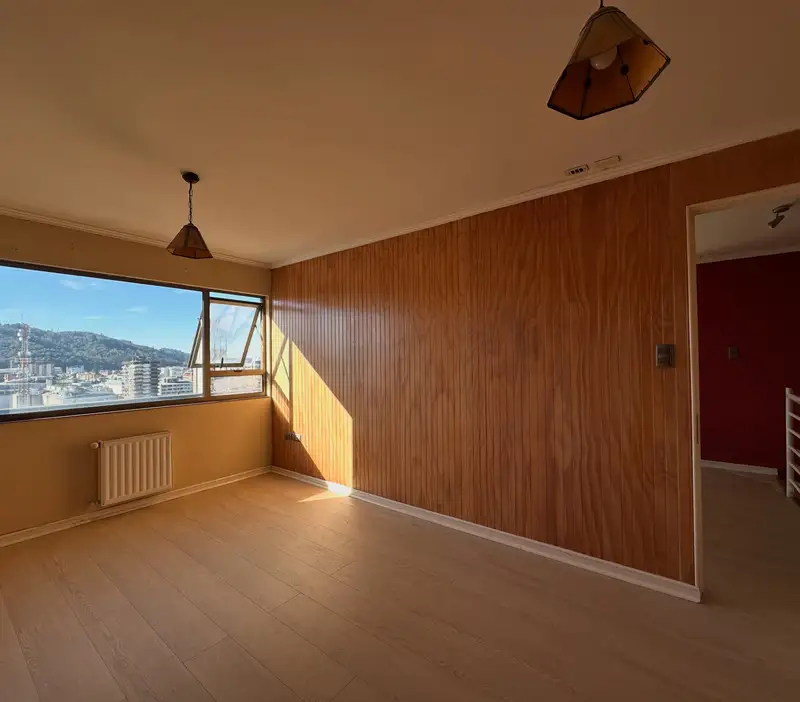 Sala de estar con ventanal panorámico del departamento en el centro de Temuco