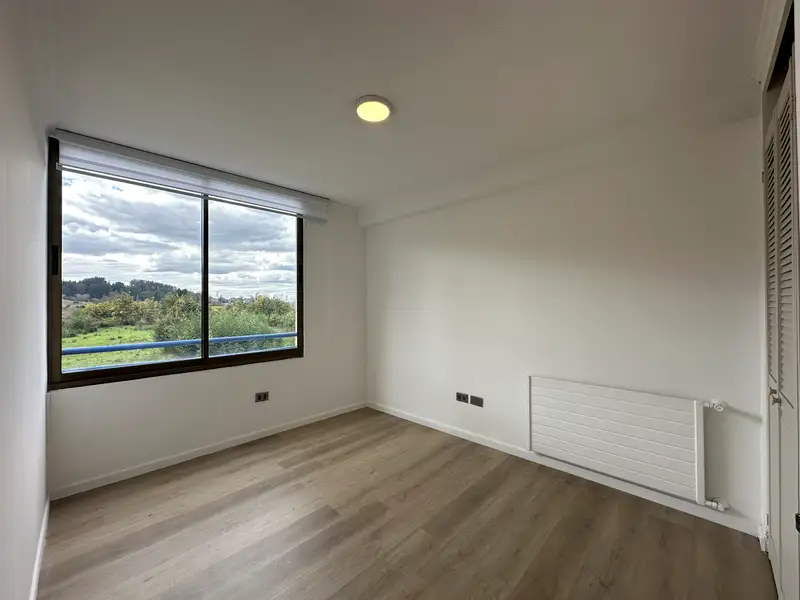 Dormitorio con vista a áreas verdes del departamento en Condominio Las Encinas, Temuco