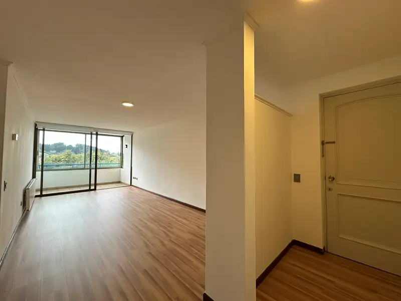 Estar-comedor y acceso principal del departamento en Condominio Las Encinas, Temuco
