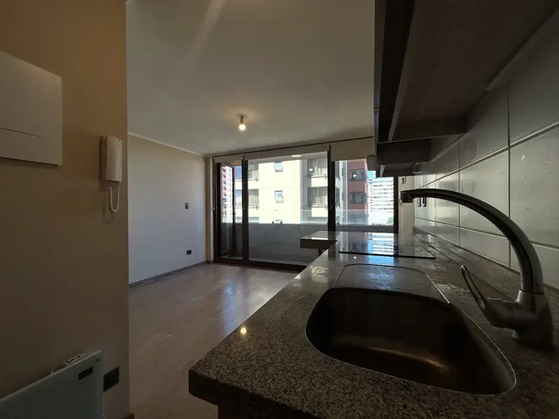 Cocina integrada y terraza del moderno studio en Temuco